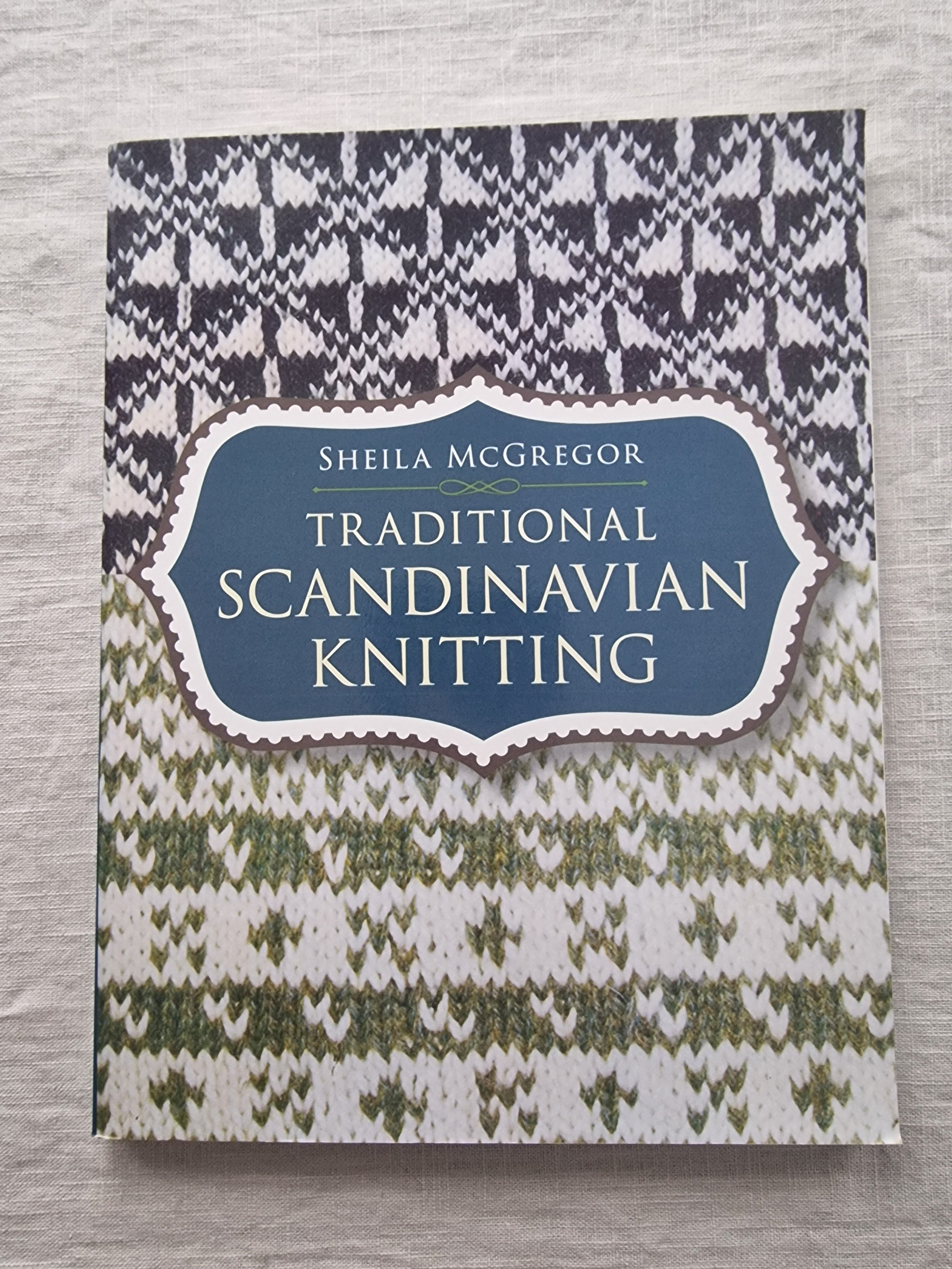Book titled 'Traditional Scandinavian Knitting' by Sheila McGregor on a wooden surface