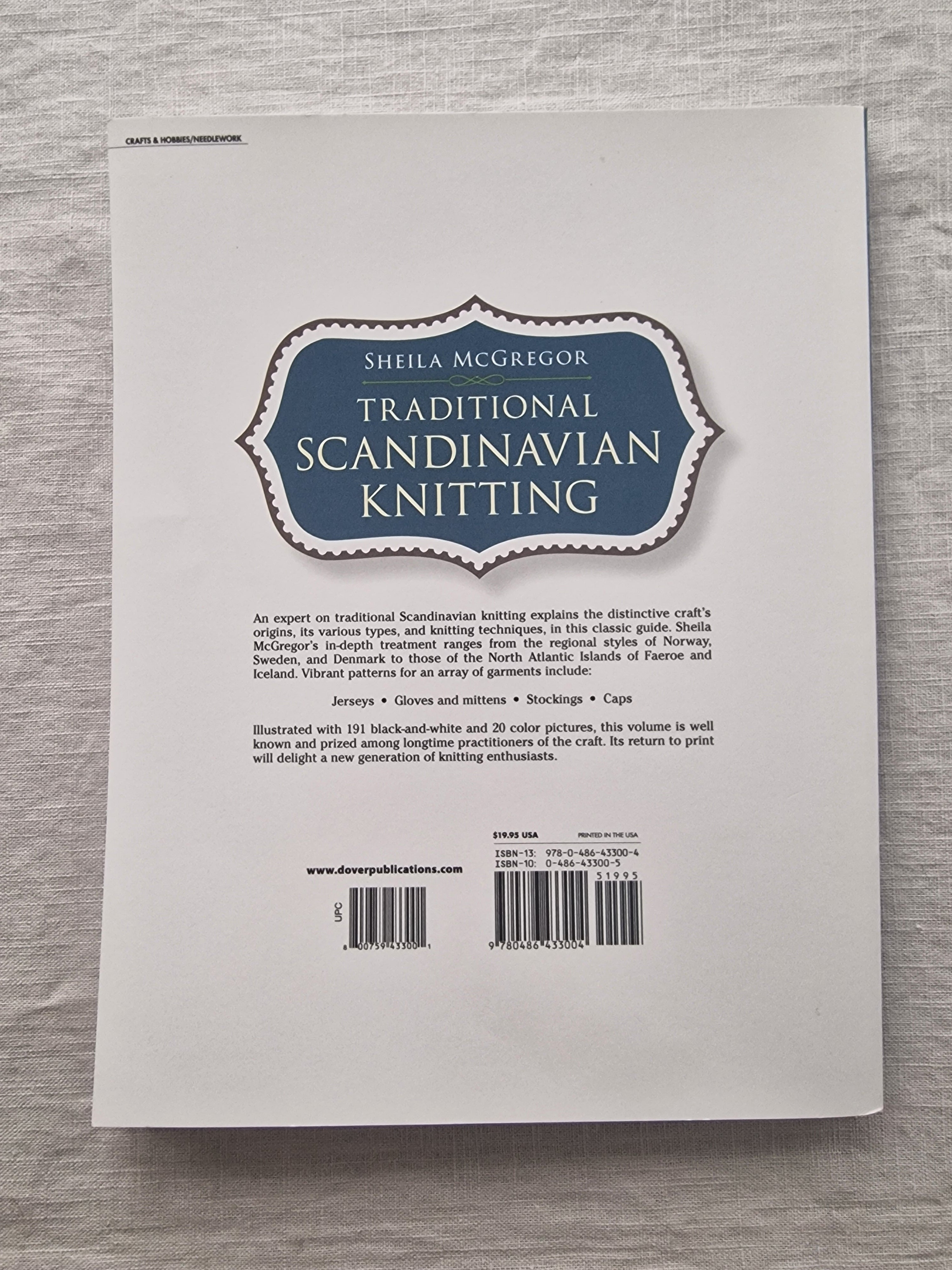 Back cover of a book titled 'Traditional Scandinavian Knitting' with a barcode on a wooden surface.