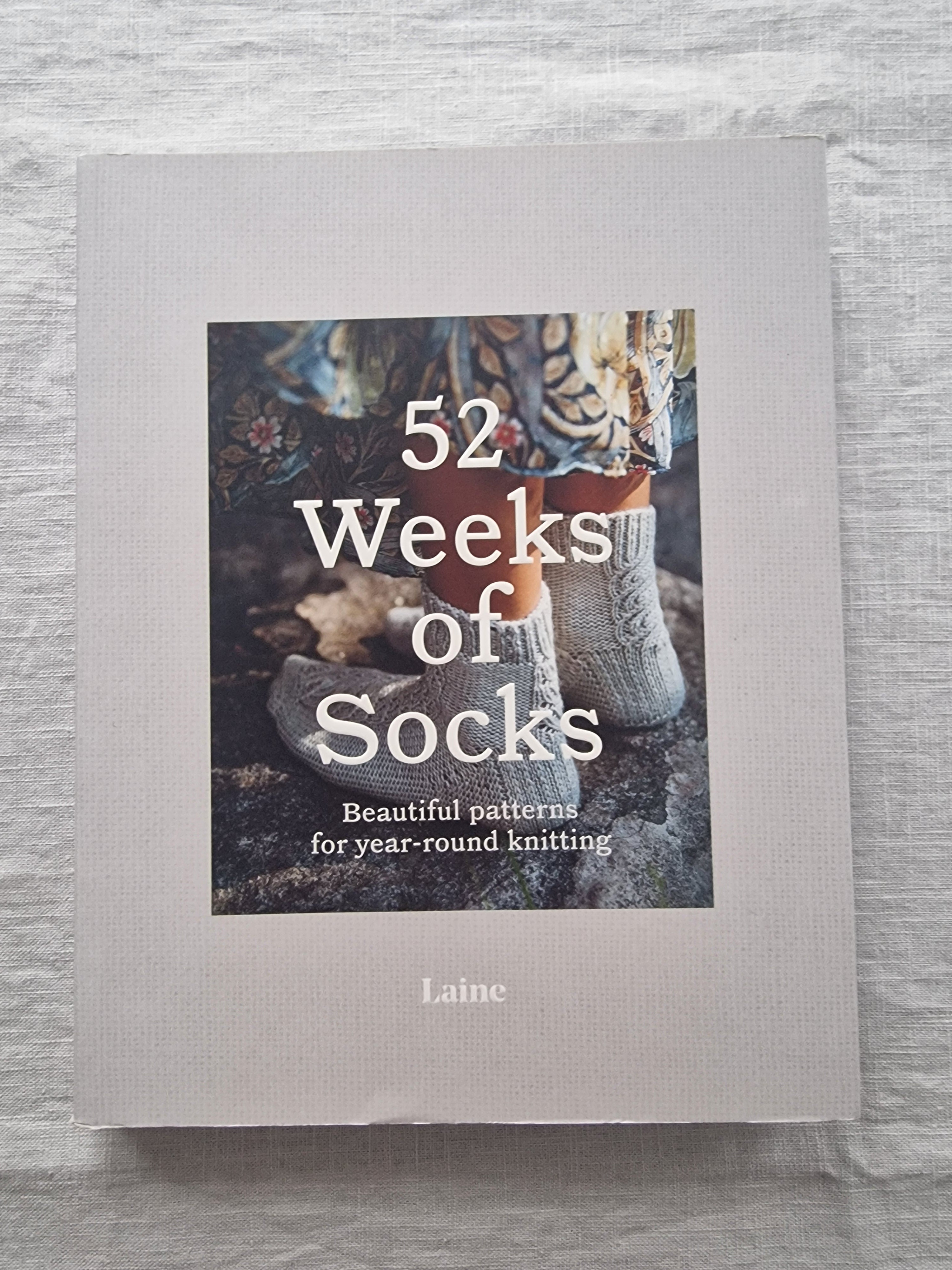 Book titled '52 Weeks of Socks' by Laine on a textured surface