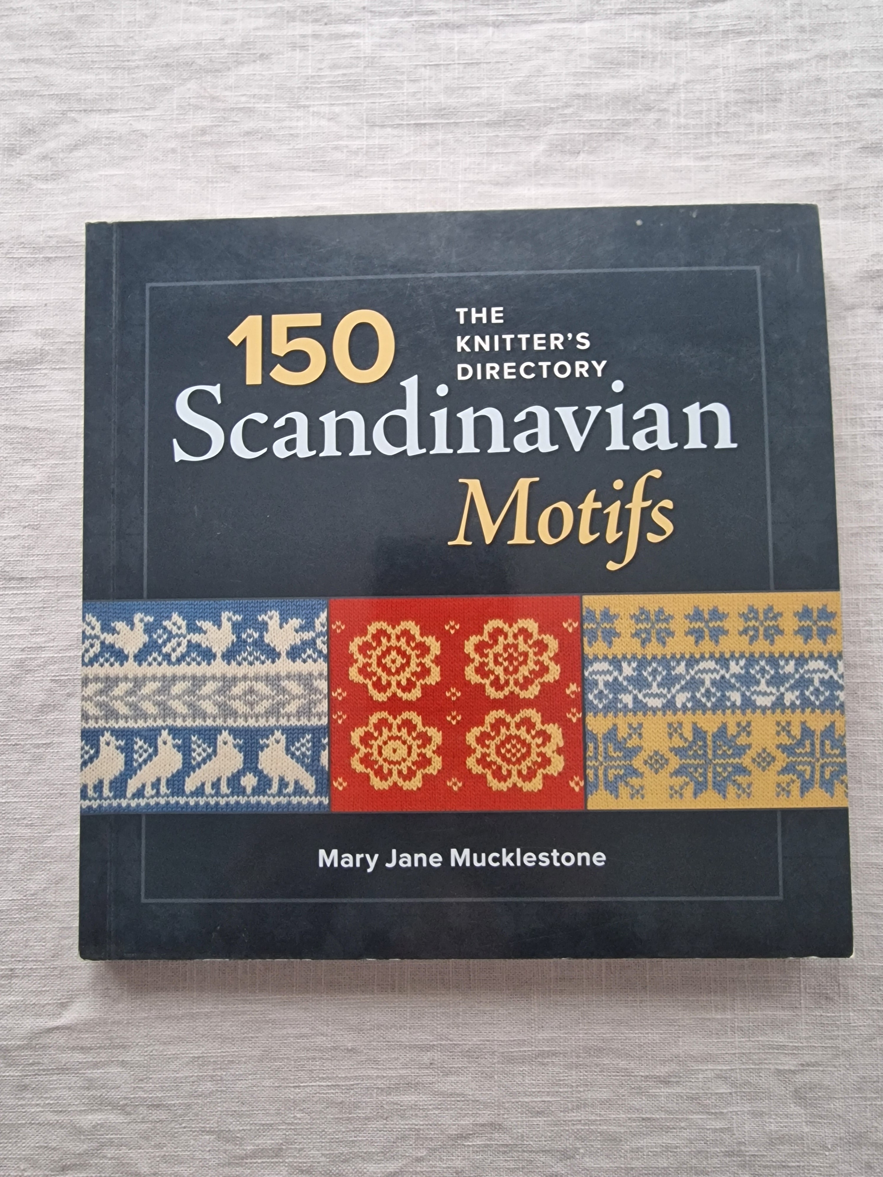 Book titled '150 Scandinavian Motifs' by Mary Jane Mucklestone on a textured surface